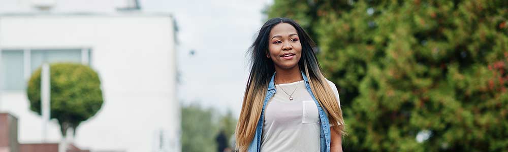 20-something woman smiling because she’s eligible for coverage due to Medicaid expansion